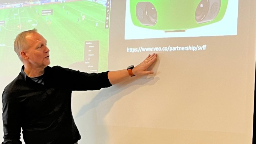 Föreläsare står vid poerpointpresentation och föreläser.