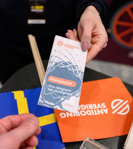 Hand som håller fram en broschyr om doping