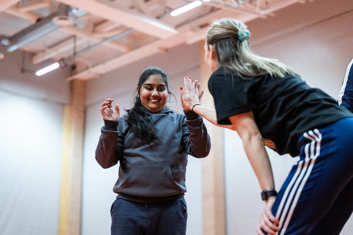 Ung ledare gör en high five med en aktiv