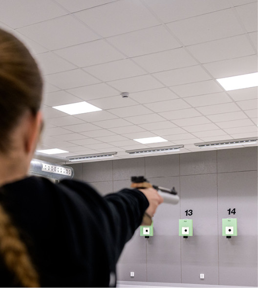 Flicka utövar pistolskytte.
