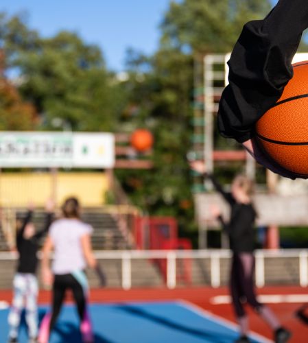 Bild på tre basketspelande ungdomar från långt håll