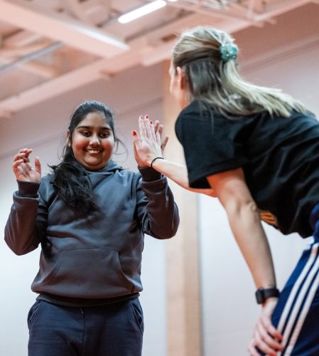 Ledare ger highfive till kvinnlig utövare