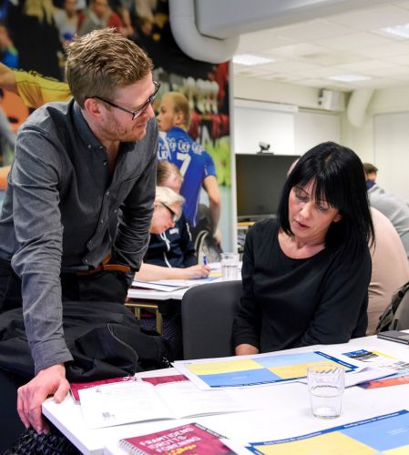 En man och en kvinna diskuterar ett dokument vid ett bord