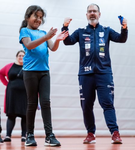 Flicka som applåderar tillsammans med sin tränare som jublar